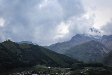 The main Caucasian ridge. Georgia, Kazbegi village (Stepantsminda). Mount Kazbek. Mountains, summer, twilight. Beautiful, amazing sky. High mountains. Vacation, hike. christian Gergeti Trinity Church