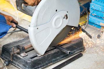 Image of worker using a sliding compound mitre saw with circular blade for cutting