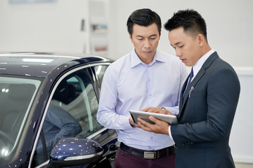 Car dealership manager working with client