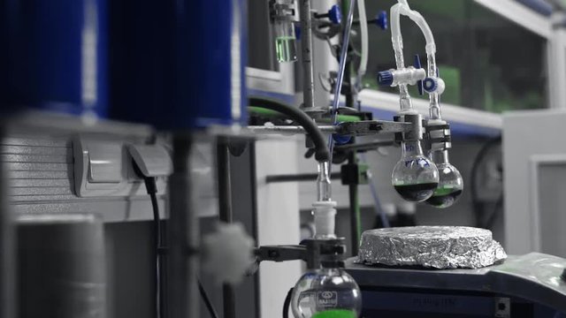 Chemistry laboratory processes. Chemical reaction, solution in tube or flask. Mixing and homogenization process in lab experiment. Medical or pharmacy industry. Scientific test, microbiology research.