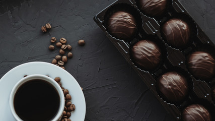 Chocolate cakes and cup of coffee on dark background