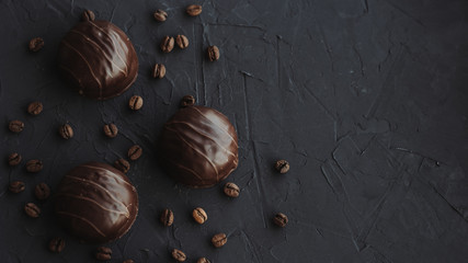 Chocolate cakes and coffee beans on a black background