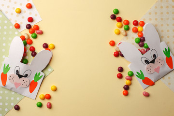 Easter colorful candy and Jellybean flowing from party paper handcraft bag on yellow white background. Easter bunny package. copy space, flat lay, Happy Easter concept