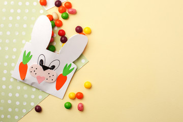 Easter colorful candy and Jellybean flowing from party paper handcraft bag on yellow white background. Easter bunny package. copy space, flat lay, Happy Easter concept