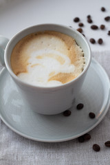 cup of cappuccino, coffee in a cup on a napkin close-up.