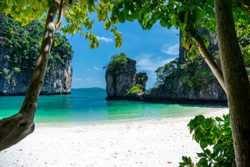A clean white-yellow sand beach and emerald water on the island at the sea of Thailand on some holiday weekend.