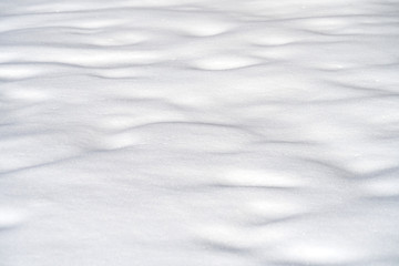 Fototapeta na wymiar snow drift covered ground texture with shadows