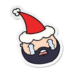 sticker cartoon of a male face with beard wearing santa hat