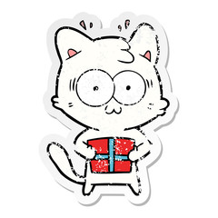 distressed sticker of a cartoon surprised cat with christmas present