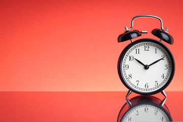 Alarm Clock on red background with selective focus and crop fragment. Business and Copy space concept