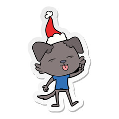 sticker cartoon of a dog sticking out tongue wearing santa hat
