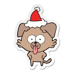 sticker cartoon of a dog with tongue sticking out wearing santa hat