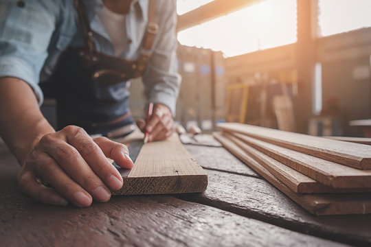 Carpenter working with equipment on wooden table in carpentry shop. woman works in a carpentry shop.