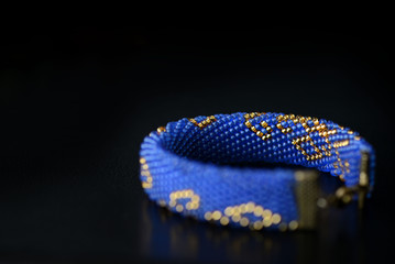 Blue bracelet with oriental print on a dark background close up