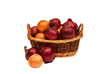 Colorful onions in wicker basket and near isolated on white.