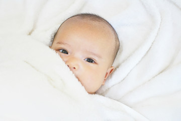 Newborn baby girl on white towel after done shower
