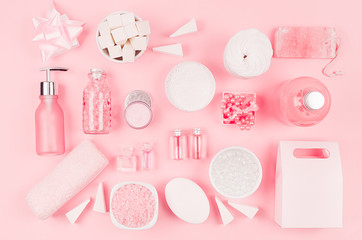 Cosmetic products for bathroom, health and hygiene in modern girlish style - decorative heart, soap, bath salt, essential oil, cream, towel, perfume, pearls, gift box on pink background.
