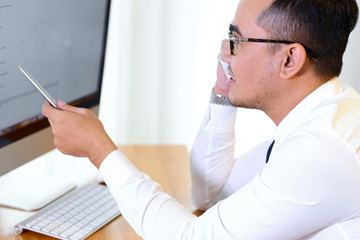 Businessman reading e-mails and calling on phone