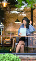 happy asian woman using tablet in cafe
