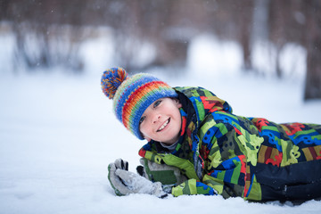 cheerful happy boy playing in winter park, outdoor