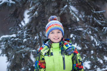 cheerful happy boy playing in winter park, outdoor