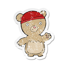 retro distressed sticker of a cartoon teddy bear wearing hat