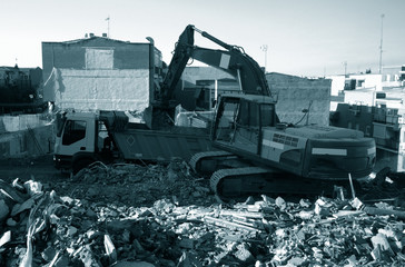 demolition team at construction site, excavator disposes demolition rubbish intro truck