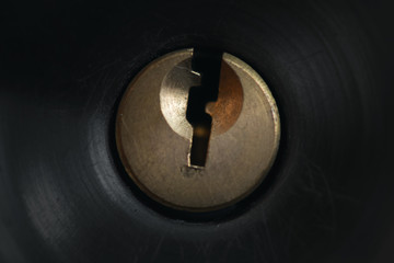 A door handle key hole on a black metal abstract background.