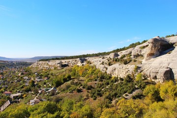 Limestone cliffs rises above the valley and the old part of the city of Bakhchisarai in the autumn on the Crimean peninsula.