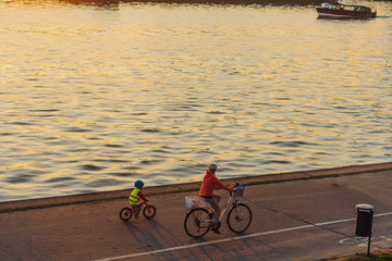 Mom and son ride bikes along the promenade © teksomolika
