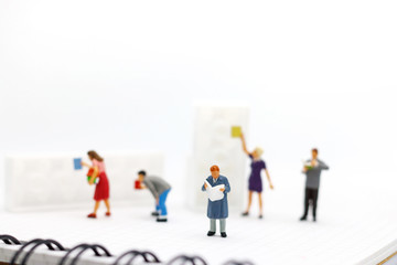 Miniature people: Business team reading book, education or business concept.