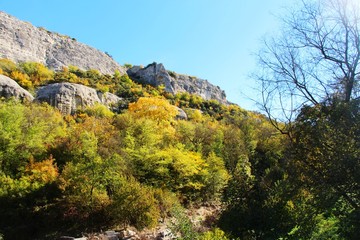 In clear weather, the rock rises above the colorful autumn forest