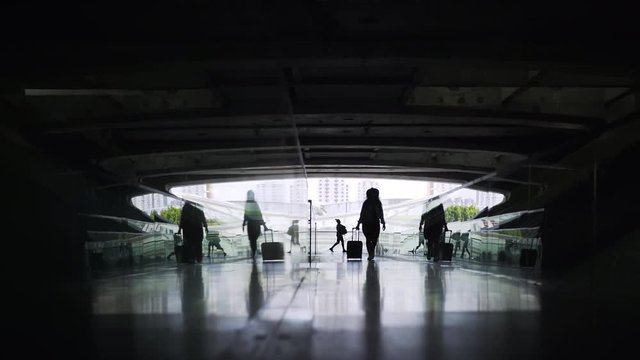 Silhouette of woman with suitcase walking inside of contemporary building Concept of modern train station or airport terminal