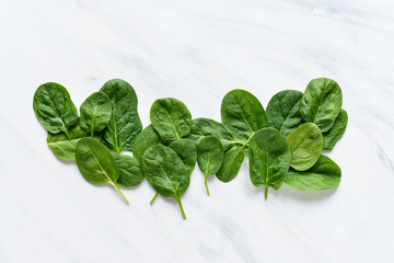 green leaves of fresh spinach on a light background, minimalism food, copy space concept of...