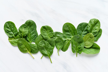green leaves of fresh spinach on a light background, minimalism food, copy space concept of vitamins and healthy food. Flat Lay vegetables and herbs, Food background
