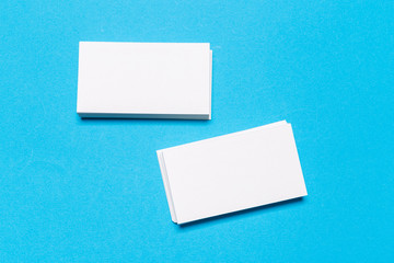 Blank white business cards on blue background. Mockup for branding identity.