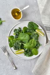 green salad of organic spinach and kale leaves with lemon juice and olive oil. diet menu concept, healthy detox food, selective focus, light background, food flat lay, salad recipe