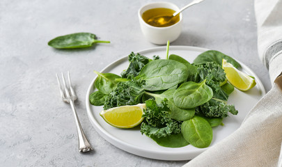 green salad of organic spinach and kale leaves with lemon juice and olive oil. diet menu concept, healthy detox food, selective focus, light background, food flat lay, salad recipe