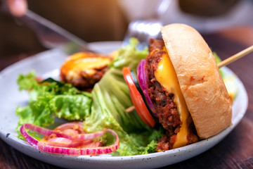 woman eating beef hamburger with knife and fork in the restaurant