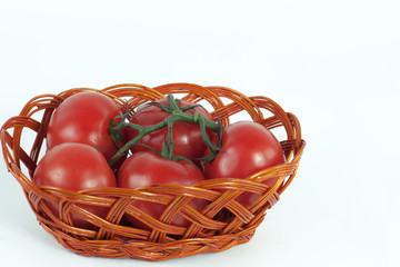 branch of ripe tomatoes in a wicker basket.isolated on white
