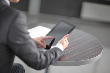 close up. businessman tapping the screen of digital tablet