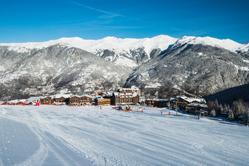 View down ski piste in alpine ski resort to village