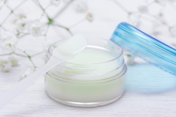 Cosmetic natural cream in a jar on a white table background.