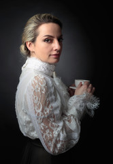Portrait of a woman in Victorian clothes with a cup of coffee.