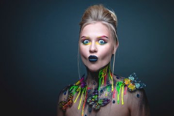 Young girl with creative makeup with butterflies