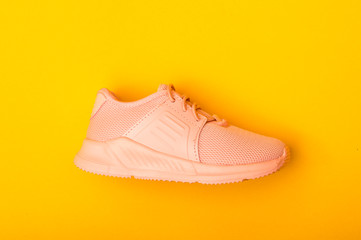 Kid's fashion pink boots on color background. Stylish new shoes on yellow background.