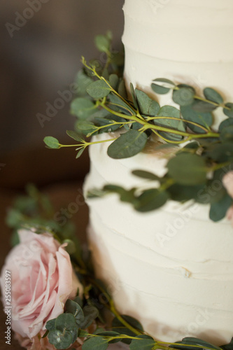 Close Up Of Wedding Cake With Greenery And Pink Rose Stock Photo