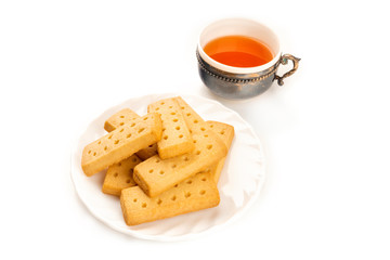 A photo of Scottish shortbreads, butter cookies on a white background with a vintage tea cup and copy space