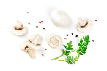 Champignon mushrooms, whole and sliced, shot from above on a white background with pepper and parsley leaves, a flat lay composition