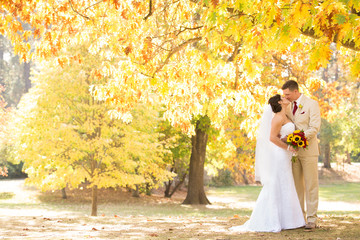 Young bride and groom in autumn park